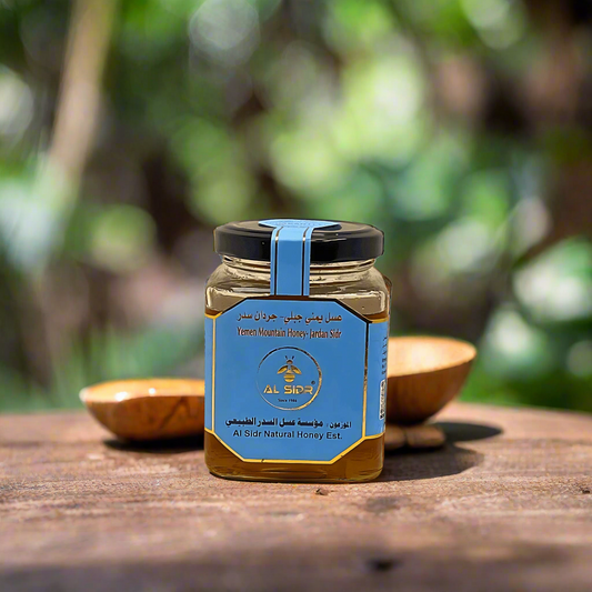 Jar of honey with blue label on a wooden surface outdoors